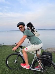 Photo of David Gallo, PhD, riding a bike with his dog