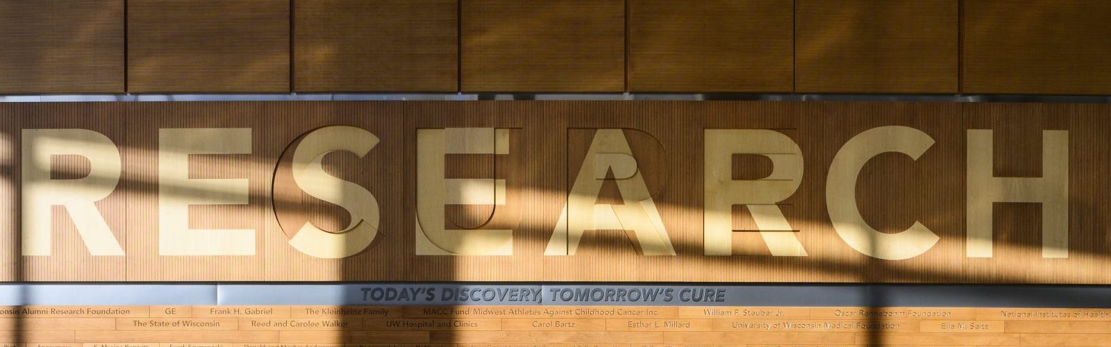Wall display reading RESEARCH with the tagline ‘Today’s Discovery, Tomorrow’s Cure'