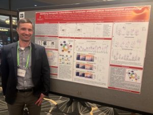 A smiling Dave Gallo is standing with his poster presentation and data in the background